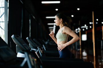 Fototapeta na wymiar Young Asian Woman Running on Treadmill - Fitness Gym Exercise