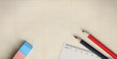 Graph paper with pencils and ruler lie on table. Teaching architectural construction drawings concept