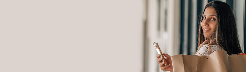 urban woman with shopping bag on the street and mobile phone