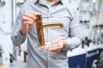 man choosing and touching faucet crane or water tap on shopping