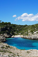 Natural landscape of crystal clear Minorca seascape bay with rocky seashore cliff and blue sky at Cala Binidali beach, Balearic Islands located in Menorca, Spain