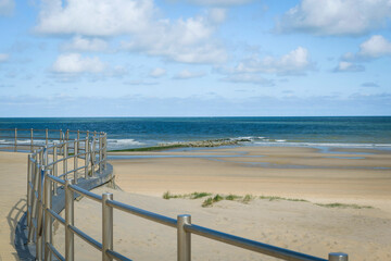 Obraz premium The embankment of a sandy beach by the sea, with beautiful metal fences.