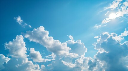 Naklejka na ściany i meble A clear blue sky with fluffy clouds lazily drifting overhead