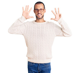 Young handsome man wearing casual clothes and glasses showing and pointing up with fingers number...