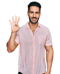Hispanic man with beard wearing casual shirt showing and pointing up with fingers number four while smiling confident and happy.