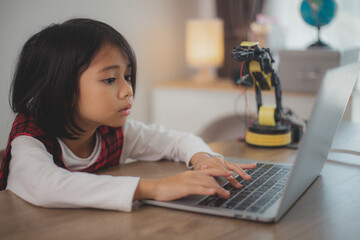 STEM education concept. Asian students learn at home by coding robot arms in STEM, mathematics...