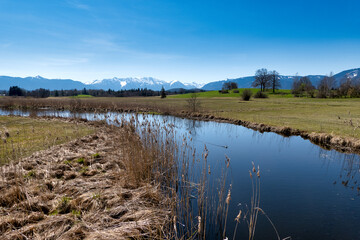 View over a stream to the Bavarian Alps