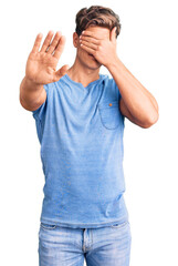 Young handsome man wearing casual clothes covering eyes with hands and doing stop gesture with sad and fear expression. embarrassed and negative concept.