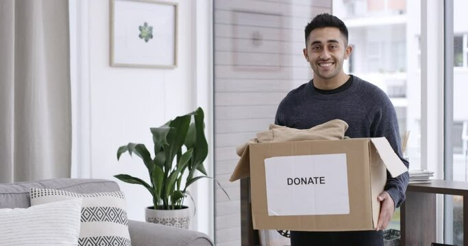 Man, face and donation in home, charity box and kindness with happy giving to ngo organisation. Volunteer, pride or smile portrait by clothing, cardboard or service to community with generosity