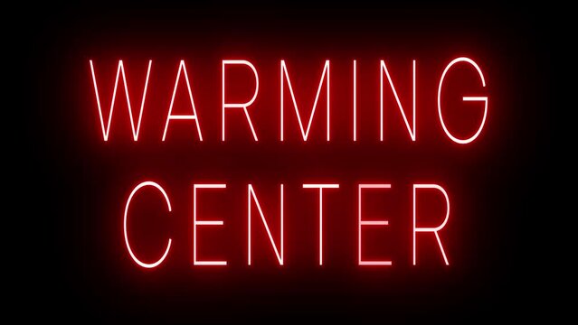 Flickering red retro style neon sign glowing against a black background for WARMING CENTER