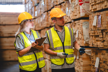 Professional Engineer, carpenter or worker team are checking and inspecting hardwood, timber or wooden pallet material for furniture production. Technician is wearing a hardhat while monitoring stock.