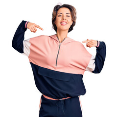 Young beautiful woman wearing sportswear looking confident with smile on face, pointing oneself...