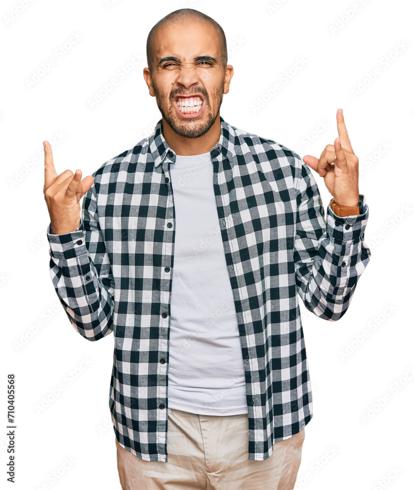 Sticker Hispanic adult man wearing casual clothes shouting with crazy expression doing rock symbol with hands up. music star. heavy concept.