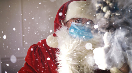 Santa Claus and christmas tree on a background, wearing a protective mask. Coronavirus Christmas....