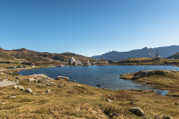 High plateau at the top of the Gotthard Pass with lake Lago della Piazza and historic buildings in the background, Canton of Ticino, Switzerland