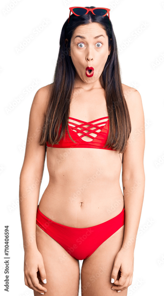 Poster young beautiful caucasian woman wearing bikini afraid and shocked with surprise expression, fear and