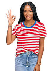 Beautiful hispanic woman wearing casual clothes smiling positive doing ok sign with hand and fingers. successful expression.