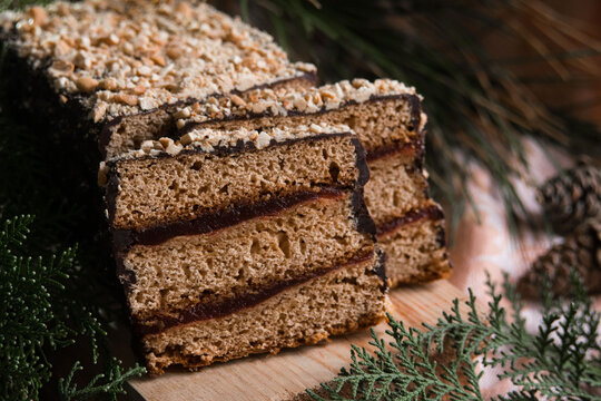 Piernik staropolski traditional christmas layered gingerbread cake with plum jam on wooden board, selective focus