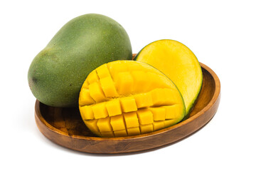 Sliced half cut into cubes and whole fresh organic green mango delicious fruit side view in a wooden plate isolated on white background clipping path