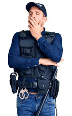 Young handsome man wearing police uniform bored yawning tired covering mouth with hand. restless and sleepiness.