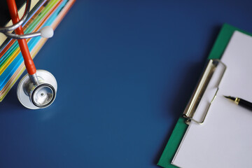 stethoscope on stack of medical guide book for doctor learning treatment at hospital.