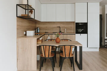 Modern home interior design. Living room with dinner table, kitchen furniture, chairs, decorations