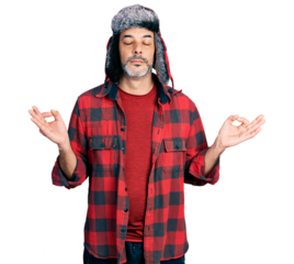 Middle age hispanic man with grey hair wearing fluffy earmuff hat relax and smiling with eyes closed doing meditation gesture with fingers. yoga concept.