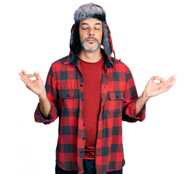 Middle age hispanic man with grey hair wearing fluffy earmuff hat relax and smiling with eyes closed doing meditation gesture with fingers. yoga concept. - Powered by Adobe