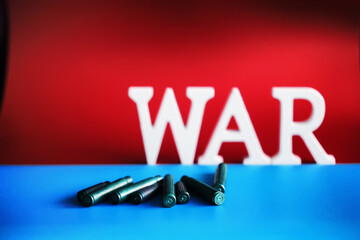 WAR, word written in wooden alphabet letters on red background. The concept of a terrible war destroying country.