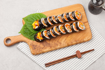 A food where rice is spread on seaweed, stuffed with various side dishes, wrapped, wrapped, and eaten sliced.


