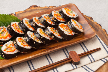 A food where rice is spread on seaweed, stuffed with various side dishes, wrapped, wrapped, and eaten sliced.


