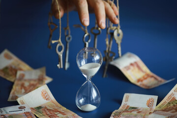 Retro keys on ropes in hand. Flying banknotes. Concept of business ideas.