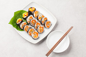 A food where rice is spread on seaweed, stuffed with various side dishes, wrapped, wrapped, and eaten sliced.


