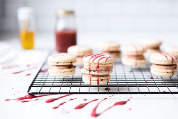 raspberry macarons with chocolate drizzle on cooling rack
