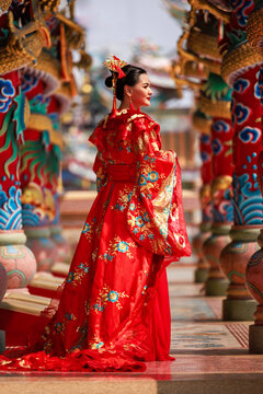 Chinese new year , Portrait of young asian woman with traditional red Chinese hong hao cheongsam in temple ,