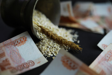 The concept of the cost of grain. 5000 ruble banknotes around a handful of ground grain. World...