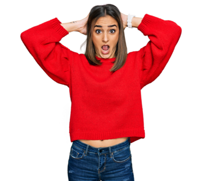 Beautiful brunette woman wearing casual winter sweater crazy and scared with hands on head, afraid and surprised of shock with open mouth
