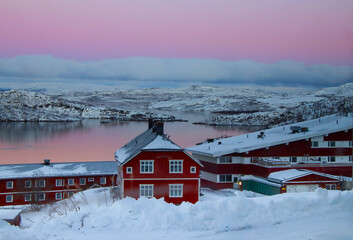 beautiful winter landscape with red houses and mountains in Norway