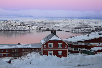 beautiful winter landscape with red houses and mountains in Norway