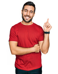 Young hispanic man wearing casual clothes smiling happy pointing with hand and finger to the side