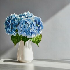 Blue hydrangea flower in white vase on gray interior