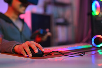 Close up of gamer holding mouse playing video game on computer at home. Gaming, esports and...