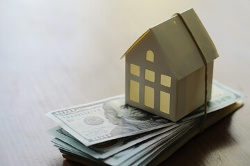 Model of cardboard house with key and dollar bills. Building, loan, real estate, cost of housing or buying a new home concept.