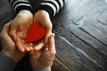 Hands of a woman holding and offering a heart shape. Love, health concept. Selective...