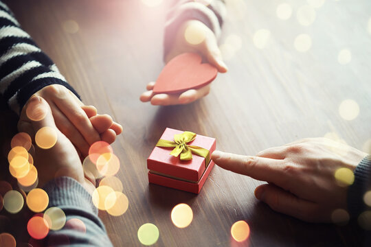 Male female hands holding gift box for birthday on wooden background. Fathers day valentine day, Christmas, New Year. Congratulations background.