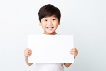Happy Asian Scholl boy holding blank white banner sign, isolated studio portrait .