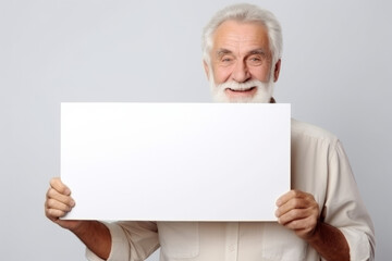 Happy old man holding blank white banner sign, isolated studio portrait.