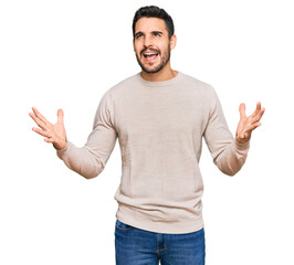 Young hispanic man wearing casual clothes crazy and mad shouting and yelling with aggressive expression and arms raised. frustration concept.
