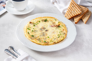 Egg omelet with mushrooms and ham for breakfast