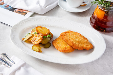 Pork schnitzel, pork cutlet with potatoes on a plate.